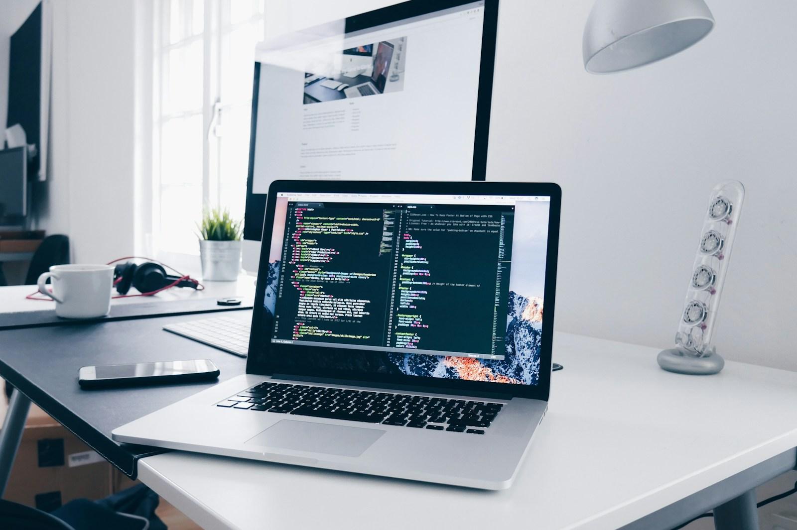 Laptop displaying software code in a digital workspace